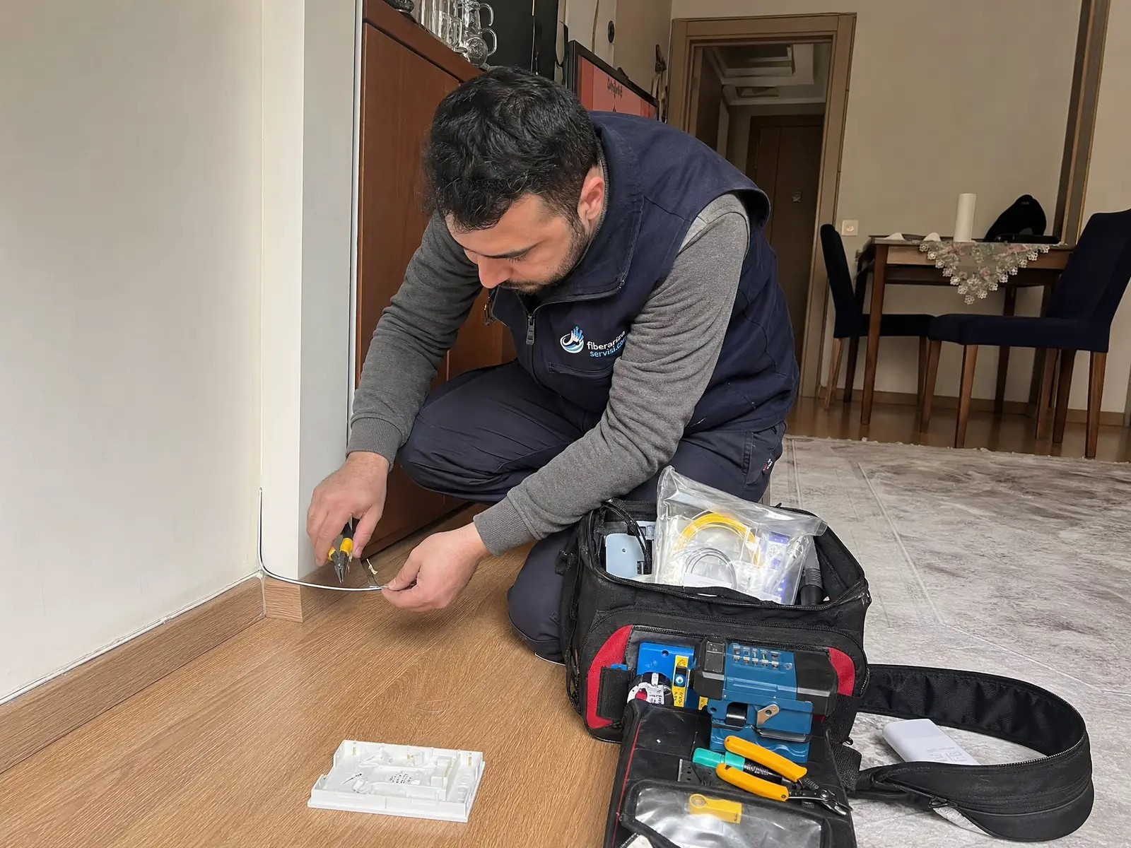 Daire içinde hasarlı fiber kablo hattını kontrol eden teknisyen